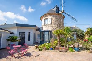 a house with a windmill in front of it at Le Petit Moulin I Plage et terrasse in Crozon