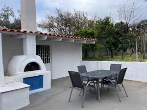 una mesa y sillas frente a un horno de pizza en AMMOR Beach houses, Nisida, en Áno Fanárion