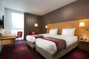 a hotel room with two beds and a desk at Park Inn by Radisson Aberdeen in Aberdeen