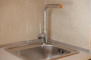 a kitchen sink with a faucet on the wall at Galatia Studios and Apartments in Benitses +27 photos