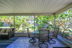 a screened in porch with a table and chairs at 1BR Venice home with private beach access - Golden Beach Haven in Venice +31 photos
