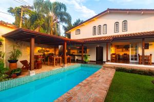 a house with a swimming pool in front of a house at Boutique Hotel Carpe Diem in Paraty