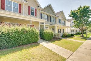 a row of houses with bushes and a sidewalk at Pets Welcome Townhome with Patio in Raleigh! in Raleigh