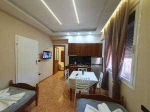 a living room with a table and a kitchen at L&G Hotel in Vlorë