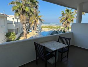een balkon met een tafel en stoelen en uitzicht op het strand bij HOTEL CARASOL VILLAS & SUITES in Ciudad Madero