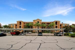 a parking lot in front of a large building at Lakefront 3rd floor condo at River Strand Golf and Country Club in Bradenton