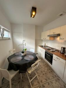 kuchnia z czarnym stołem, krzesłami i kuchenką w obiekcie Loft Living - Köln - Ehrenfeld w Kolonii +2 zdjęcia