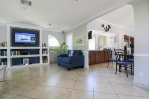 a living room with a blue chair and a tv at Resort-style living near IMG, Anna Maria Island, and Bradenton Beach in Bradenton
