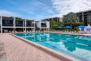 a large swimming pool with chairs and umbrellas at Charming 2 BR Longboat Key condo with ocean view in Longboat Key