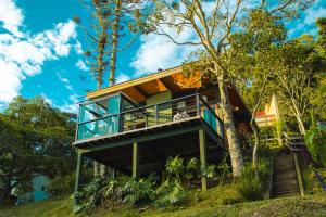 a house on a hill with a tree at Cabana Mantiká in Sapucaí-Mirim
