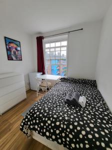 a bedroom with a black and white bed with a window at Marvellous property for 8 people in Battersea - Zone 1, 3 min walking from the main Station in London