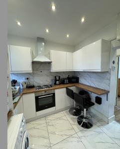 a kitchen with white cabinets and a black chair at Marvellous property for 8 people in Battersea - Zone 1, 3 min walking from the main Station in London