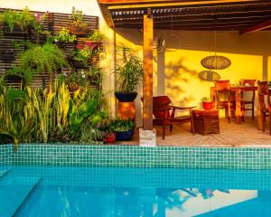 a house with a swimming pool and a dining area at Boutique Hotel Carpe Diem in Paraty