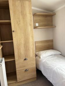 una piccola camera con letto e armadi in legno di Two bedroom Holiday Home with countryside view a St Austell Altre 25 foto