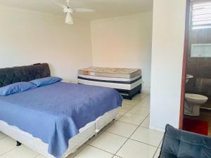 a bedroom with a bed and a toilet in it at CASA de PRAIA ESPETACULAR CHURRAS, PISCINA E SINUCA in Jacaraípe +33 photos