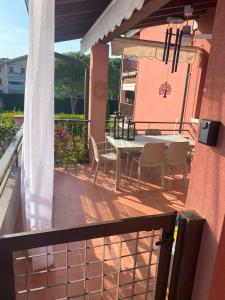 eine Terrasse mit Tisch und Stühlen auf einem Balkon in der Unterkunft Sosien Apartments in Desenzano del Garda + 51 Fotos