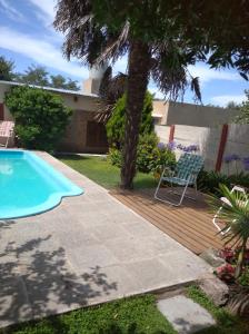 een zwembad in een tuin met een stoel naast een boom bij Casa de Olga in Tandil