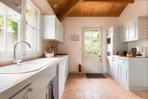 a kitchen with white cabinets and a sink at Le Marais Aixois - Grande maison familiale in Île dʼAix