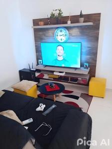 a living room with a tv and a couch at Apartamento centralizado à poucas quadras do mar. in Tramandaí