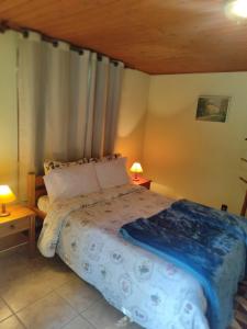 a bedroom with a bed and two lamps on tables at Chale Chez Nous in Monte Verde +8 photos
