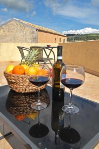two glasses of wine and a basket of fruit on a table at Sud Casa Vacanze in Ragusa