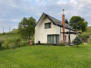 a white house with a chimney on top of a yard at Odăile Craiului in Şirnea