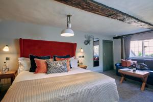 ein Schlafzimmer mit einem großen Bett mit rotem Kopfteil in der Unterkunft The Stag on the River in Godalming