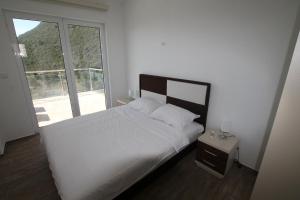 a bedroom with a white bed and a large window at Apartments Marovic in Herceg-Novi +47 photos