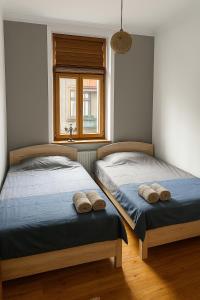 two beds sitting in a room with a window at Rio Apartment Old Town Sarajevo in Sarajevo