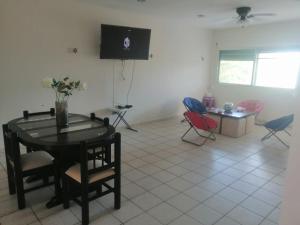 ein Wohnzimmer mit Tisch und Stühlen und einem Fernseher in der Unterkunft Casazul oceanfront in Chelem! in Chelem