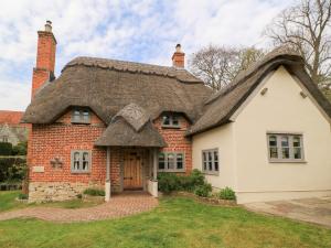 an old house with a thatched roof at Cosy Cot in Stoford