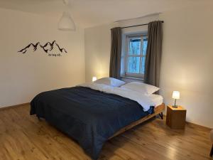 Un dormitorio con una cama grande con ventana. en Rosenhäusl, en Schönau am Königssee