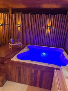 a large blue tub in a room with wooden walls at Urban dream, chalé temático in Goiânia