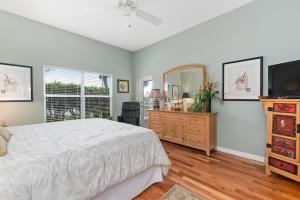 a bedroom with a bed and a dresser and a television at Tranquil 2BR lakefront home in Palmer Ranch in Sarasota
