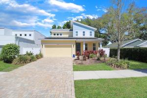 a white house with a garage on a driveway at Modern 4 BR home in the heart of Sarasota in Sarasota