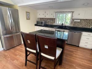 a kitchen with a counter with chairs and a refrigerator at Salem's Enchanted Inn in Salem