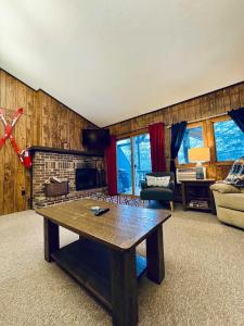 ein Wohnzimmer mit Tisch und Kamin in der Unterkunft Cozy Ski Lodge Condo I Alpen Villas at Powderhorn Mountain in Bessemer