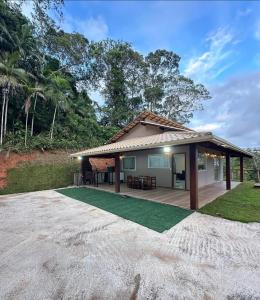 a house with a patio and a lawn at Chácara Vista da Mata in Marechal Floriano
