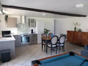 a kitchen and dining room with a table and chairs at Spacieux T3 avec jardin dans belle béarnaise in Lanne-en-Barétous 