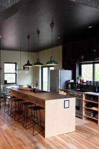 una cucina con una grande isola con sgabelli da bar di Lokal Chalet - Modern Cabin in the NJ Pine Barrens a Egg Harbor City