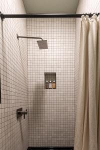 un bagno con doccia e 2 bottiglie di Lokal Chalet - Modern Cabin in the NJ Pine Barrens a Egg Harbor City