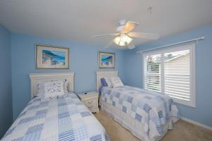 ein Schlafzimmer mit zwei Betten und einem Deckenventilator in der Unterkunft Beautiful lakefront 2BR condo in Heritage Oaks Golf and Country Club in Vamo