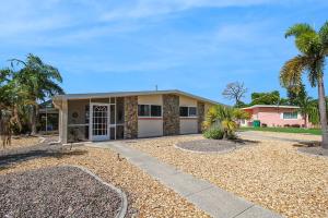 夏洛特港Canal-Front Escape with Private Pool & Game Room in Port Charlotte的一栋门前有棕榈树的房子