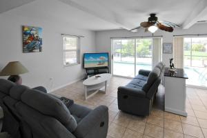 夏洛特港Canal-Front Escape with Private Pool & Game Room in Port Charlotte的有两张沙发和一台电视的客厅