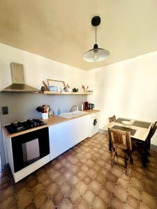 a kitchen with a stove and a sink and a table at Bel appartement Hôtel de ville in Bourganeuf +9 photos