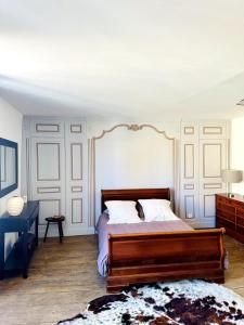a bedroom with a wooden bed with white walls at Bel appartement Hôtel de ville in Bourganeuf