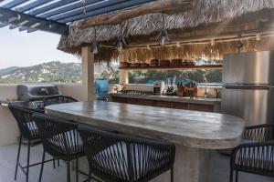 a kitchen with a large counter with chairs around it at Casa Salita in Sayulita