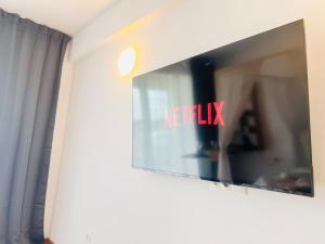 une télévision sur un mur avec les mots helliki dans l'établissement Studio Ivana by Blaxy Residence, à 23 August