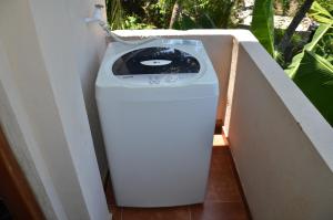 a washing machine sitting in the corner of a room at White House Apartment at Hume's Road in Galle