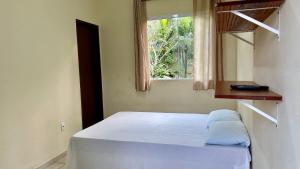 a bed in a room with a window at Suites Oceano in Caraguatatuba